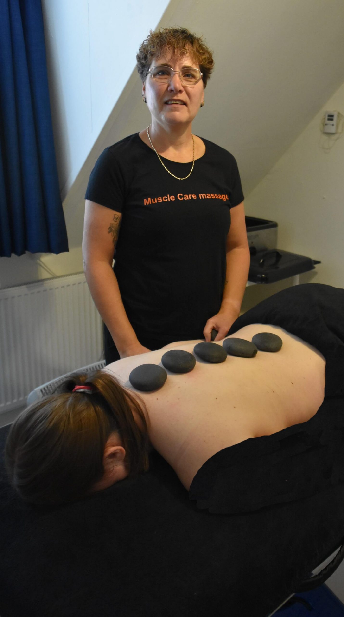 Vrouw op massagetafel van Musclecare Meppel die een hotstone massage krijgt